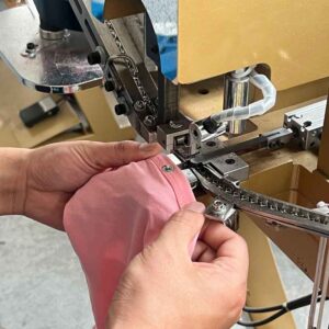 Fastener attachment for baby clothing manufacturing process